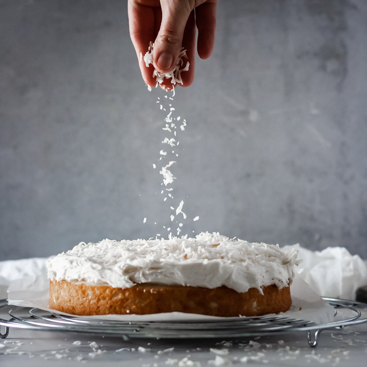 Front view of coconut being sprinkled on a Raffaello cake