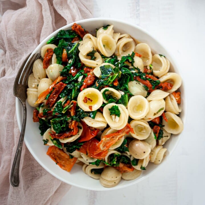 Overhead view of a bowl of sun dried tomato and kale pasta