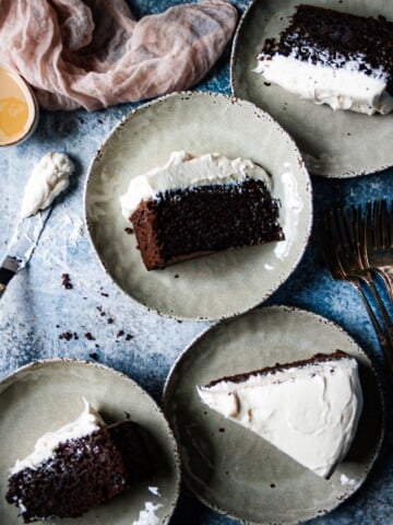 Slices of Baileys chocolate cake with buttercream frosting on plates with forks