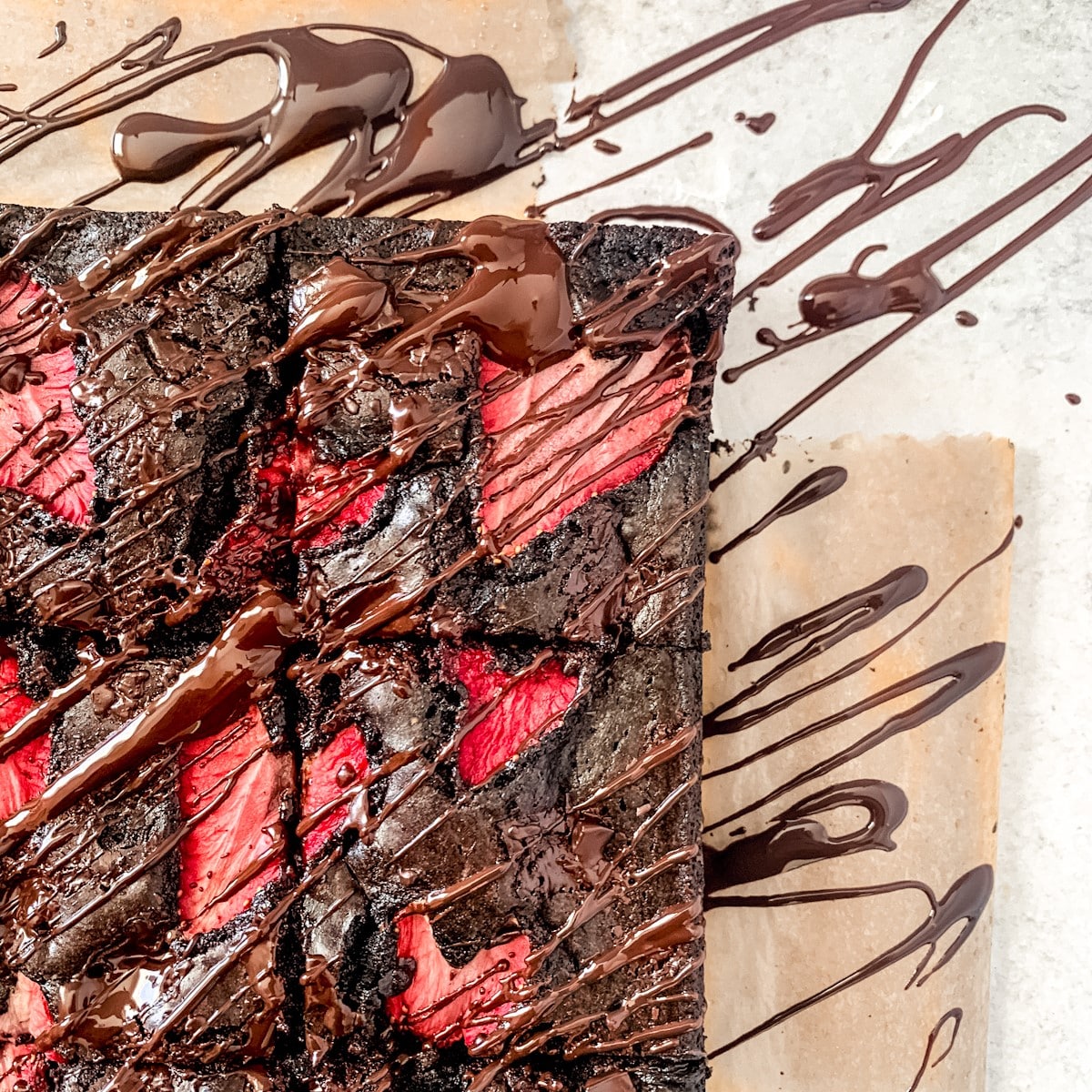 Closeup of sliced strawberry brownies with chocolate drizzle.