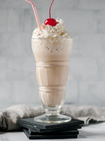 Nutella milkshake in a glass with whipped cream and a cherry