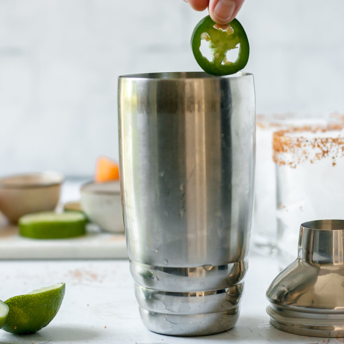 jalapeno slice dropping into a cocktail shaker